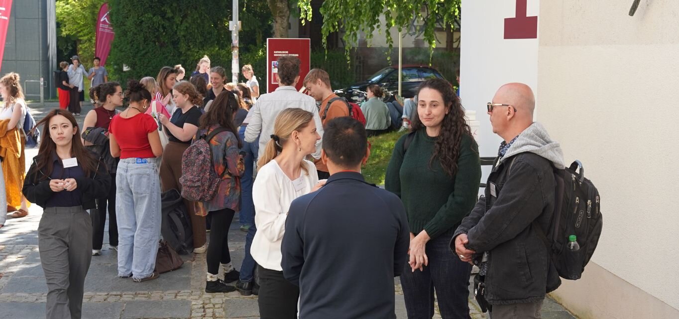 Gäste der International Week und Angehörige der KH Freiburg in angeregtem Austausch vor Haus 1 der KH Freiburg