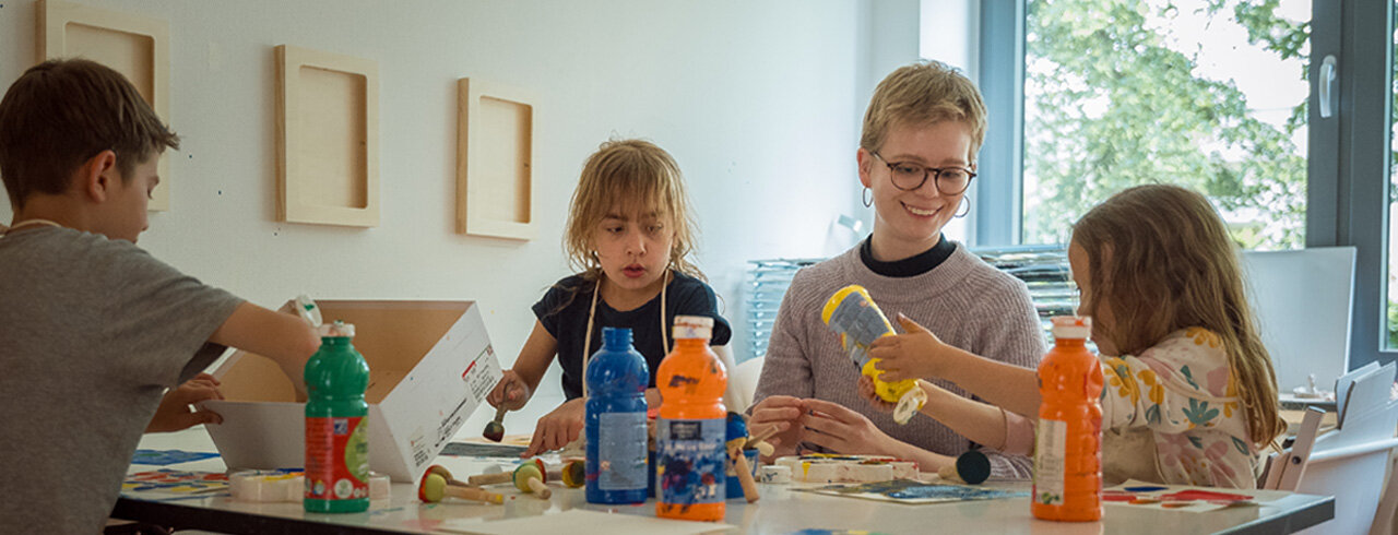 Studierende mit Kindern in einer kunsttherapeutischen Situation