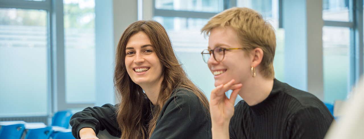 Zufriedene, fröhlich lächelnde Studierende