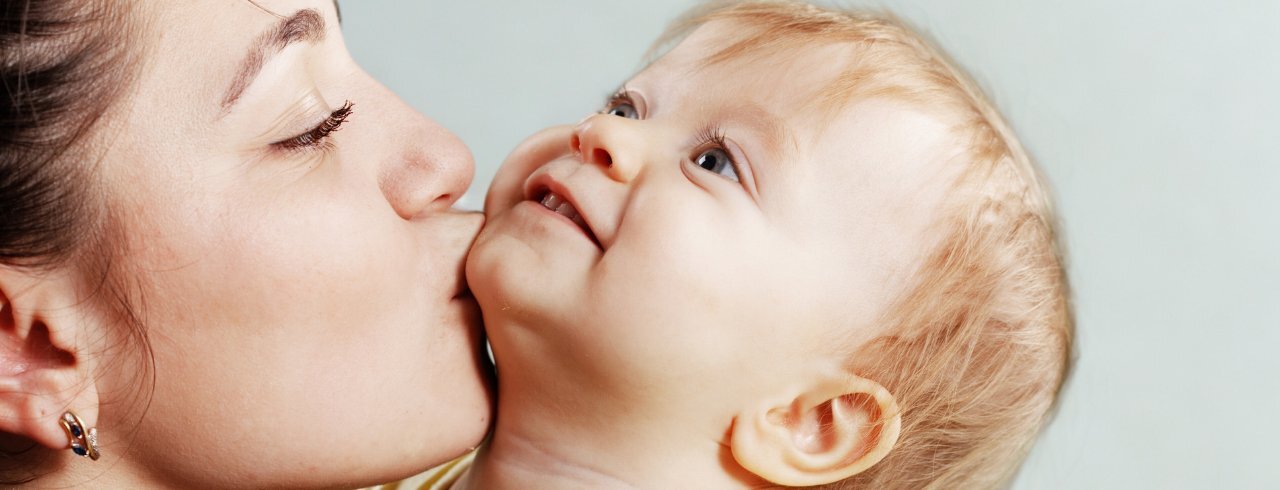 Eltern Kind Bindung: Mutter küsst ihr Kleinkind