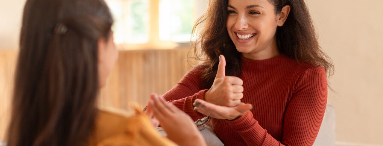 zwei Personen in einer Unterhaltung ohne Worte. Sie nutzen ihre Hände.